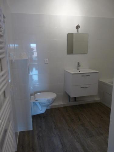 uma casa de banho branca com um WC e um lavatório em Joli appartement quartier Brassens 55 m2 à 2 mn du centre ville em Sète