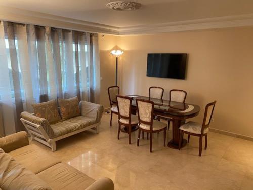 un salon avec une table, des chaises et un canapé dans l'établissement Chez Babette, à Cannes