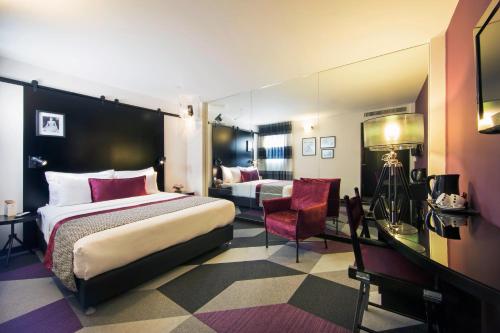 a hotel room with a bed and a desk and chair at Cinema Hotel - an Atlas Boutique Hotel in Tel Aviv