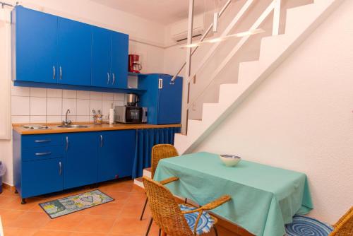 a kitchen with blue cabinets and a table with a sink at Sidar-Old Town in Cres