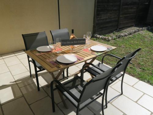 une table en bois avec quatre chaises autour dans l'établissement Chez Marielle, à LʼIsle-sur-la-Sorgue