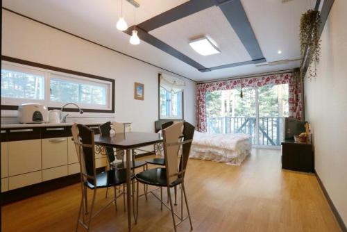 a kitchen and dining room with a table and chairs at Blue Sky Milky Way Pension in Yangyang
