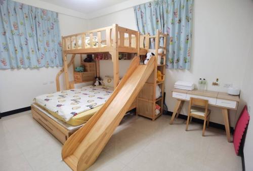 a wooden bunk bed in a room with a desk at Kinmen Huquian 58 in Jinhu