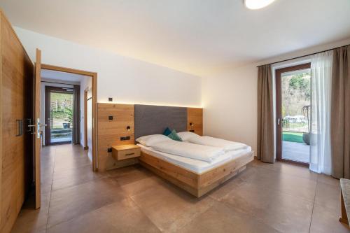 ein Schlafzimmer mit einem Bett und einem großen Fenster in der Unterkunft Camping Passeier Garten in Saltaus