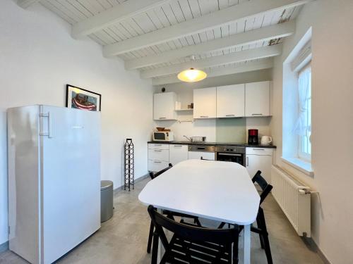 Il comprend une cuisine équipée d'une table blanche et d'un réfrigérateur. dans l'établissement COC - L'Étoile Du Marin, à Wissant