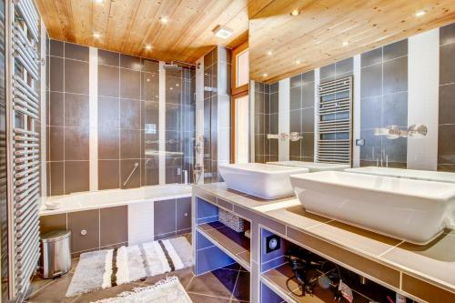 une salle de bain avec deux lavabos et un grand miroir dans l'établissement Le Mélèze, à Morzine
