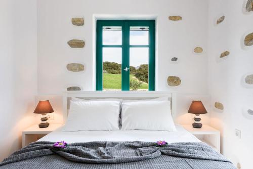 a bedroom with a bed and a window at seaside Ktima KaParos PAROS in Drios
