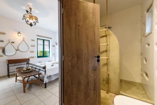 a bathroom with a door leading to a bedroom at seaside Ktima KaParos PAROS in Drios
