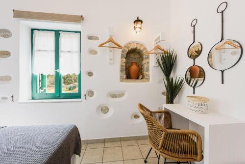 a bedroom with a bed and a desk and a window at seaside Ktima KaParos PAROS in Drios