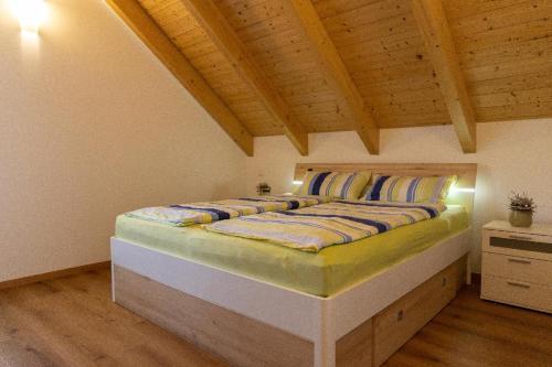 Cama grande en habitación con techo de madera en Ferienwohnung Schäffer mit Klimaanlage und Freisitz im Garten en Essing