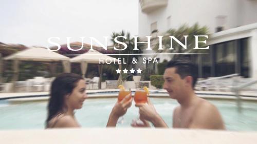 a man and a woman holding drinks in a swimming pool at Sunshine Club Hotel Centro Benessere in Ricadi