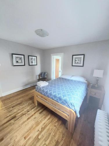 a bedroom with a bed with a blue comforter at Elcho's ExplOre Ottawa #3 in Ottawa