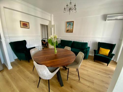 a dining room with a table and chairs and a couch at Le Nid Blanc Nice Centre in Nice