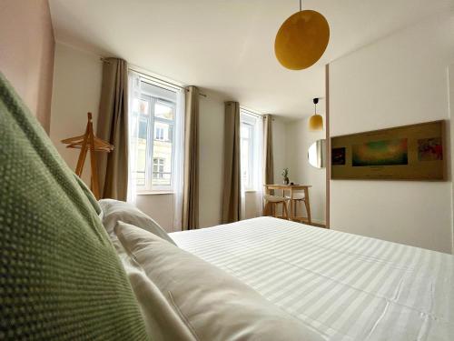um quarto com uma cama branca e uma janela em Demeure Rossini Cholet Centre em Cholet