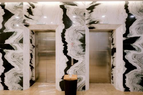 a bathroom with black and white walls and a elevator at Goldberry Suites and Hotel Cebu in Cebu City