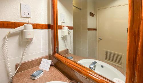 a bathroom with a mirror and a sink at Sarova Lion Hill Game Lodge in Nakuru