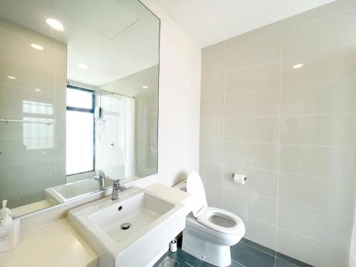 a white bathroom with a toilet and a sink at Midvalley Southkey Mosaic Suite by Nest Home in Johor Bahru