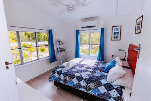 a bedroom with a bed and two windows at Kooyong Apartment 8 in Arcadia