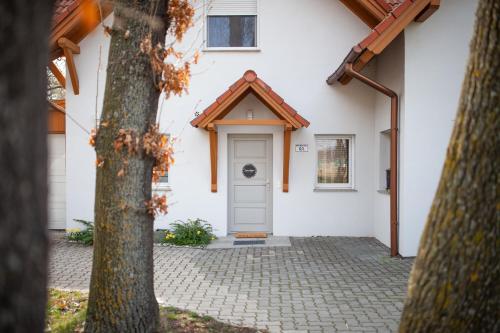 a white house with a gray door at Silver Willow Luxury Apartment in Sopron