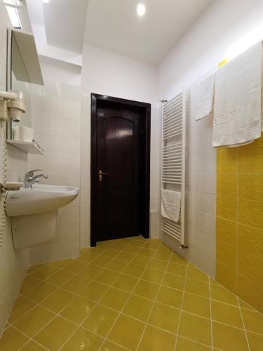 a bathroom with a sink and a black door at Hotel New Derby in Constanţa