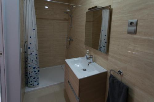 a bathroom with a sink and a shower with a mirror at Cal Rajoler in Cabanes