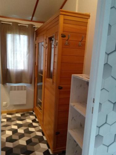 a bathroom with a wooden cabinet and a checkered floor at le haut village Chambre d'hôtes Mobi-Loft cosy sauna ,douche ,chromothérapie in Arrest