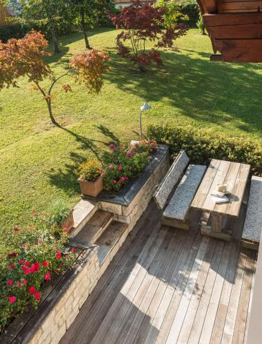 a wooden deck with benches and flowers in a yard at Landhaus Alte Salzstraße - Your Austrian Home in Bad Aussee