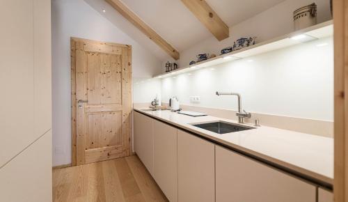 a kitchen with a sink and a wooden door at Landhaus Alte Salzstraße - Your Austrian Home in Bad Aussee