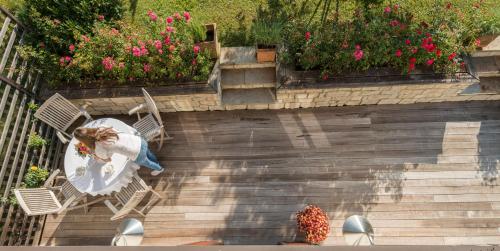 a woman sitting on a chair on a staircase with flowers at Landhaus Alte Salzstraße - Your Austrian Home in Bad Aussee