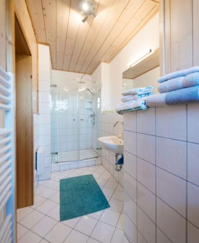 a white bathroom with a shower and a sink at Landhaus Alte Salzstraße - Your Austrian Home in Bad Aussee