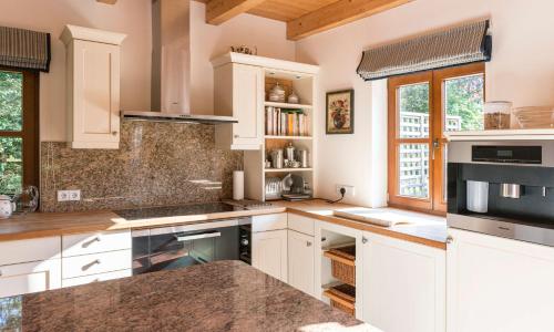 a kitchen with white cabinets and a counter top at Landhaus Alte Salzstraße - Your Austrian Home in Bad Aussee