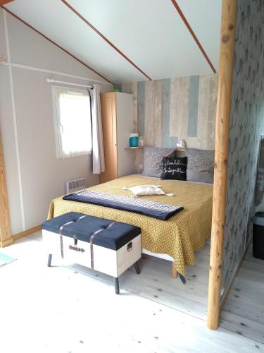 a bedroom with a bed with a yellow bedspread at le haut village Chambre d'hôtes Mobi-Loft cosy sauna ,douche ,chromothérapie in Arrest