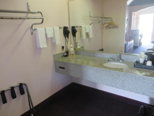 a bathroom with a sink and a mirror at Travelers Inn and Suites Liberty in Liberty