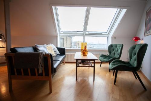 ein Wohnzimmer mit einem Sofa, 2 Stühlen und einem Tisch in der Unterkunft Harbour View / Marina / City Centre in Tórshavn