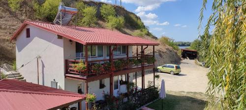 a house with a car parked next to a mountain at Casa Victoria in Nufăru