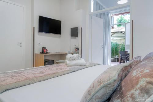 a bedroom with a large bed with a tv on the wall at Hotel Cosmos in Florence