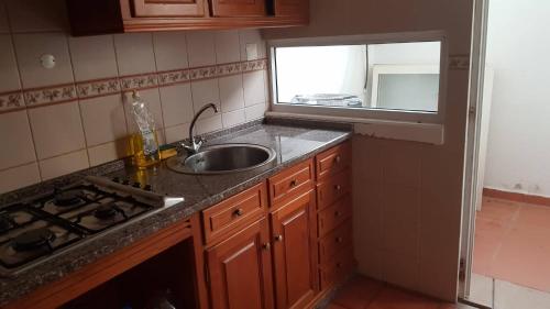 uma cozinha com um lavatório, um fogão e uma janela em Dunas House em Giz