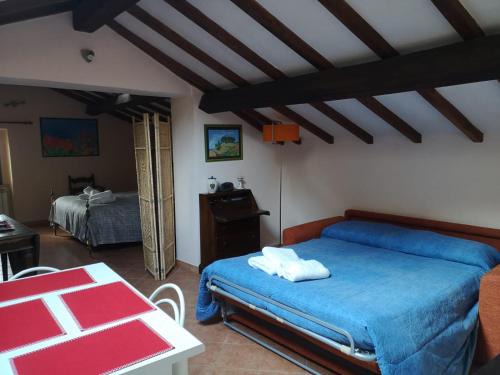 a bedroom with a blue bed and a table at La mansarda del Sacro Bosco in Bomarzo