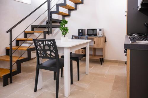 a kitchen with a table and chairs and stairs at A casudda in Noto