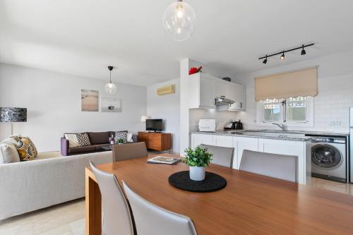 クークリアにある2 bedroom Apartment Avdimou with stunning sea views, Aphrodite Hills Resortのキッチンとテーブルとソファのあるリビングルーム