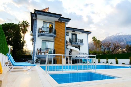 a villa with a swimming pool and a house at Roxapart Hotel in Kemer