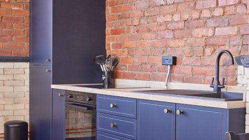 a kitchen with a sink and a brick wall at No 7 at Simpson Street Apartments Sunderland in Sunderland