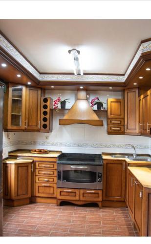 a kitchen with wooden cabinets and a stove top oven at TOLEDO ENCANTADO Piscina y BBQ privada 2,5 km de Puy du Foy in Argés