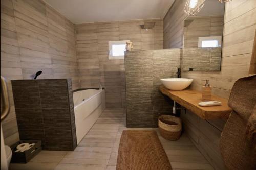 a bathroom with a tub and a sink and a bath tub at L'Hortet del iaio in Camarles