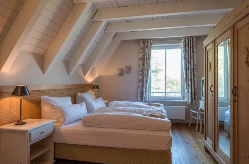 a bedroom with a large bed with a coffered ceiling at Reetdachhaus Möwe mit Schwimmteich in Krienke in Krienke