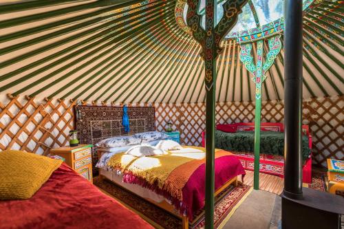 a room with two beds in a yurt at Wellstone Yurts - Red Kite in Llanfyrnach