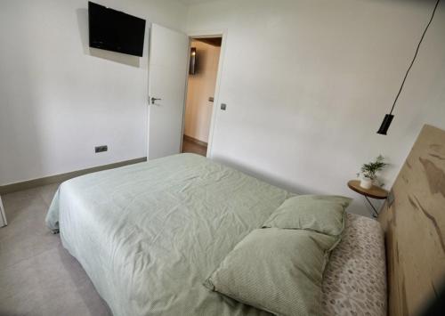 a bedroom with a bed and a flat screen tv at L'Hortet del iaio in Camarles