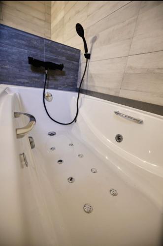a bathroom with a bath tub with a black cord at L'Hortet del iaio in Camarles