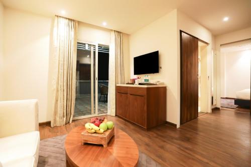 a living room with a bowl of fruit on a table at Regenta Suites Gurugram, Sector 49 Sohna Road in Gurgaon