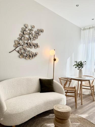 un salon avec un canapé blanc et une table dans l'établissement Le Flocon, à Saint-Étienne